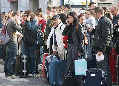 Foto tratta da El Periodico: viaggiatori provenienti da Valencia aspettano un autobus a Tarragona per raggiungere Barcellona